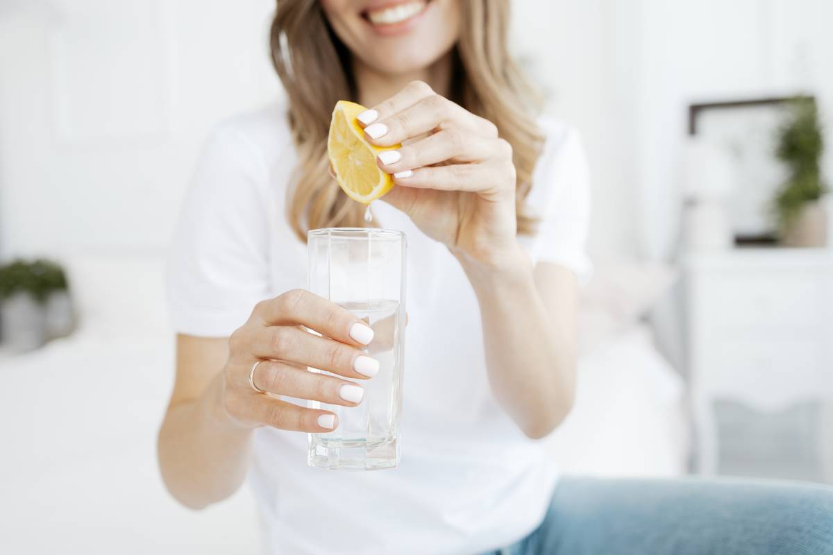 donna che prepara il suo bicchiere di acqua e limone per iniziare al meglio la giornata